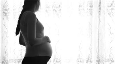  孕妇轻抚摸怀孕肚子站在窗口中景实拍特写